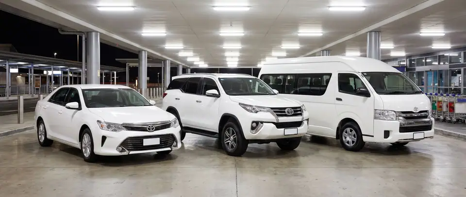 Sedan, SUV and van at an airport pickup zone at night